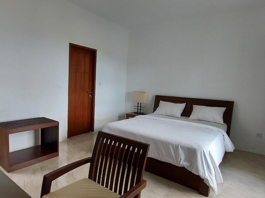 圣吉吉阿亚古纳别墅旅馆的一间卧室配有一张床、一把椅子和一张桌子