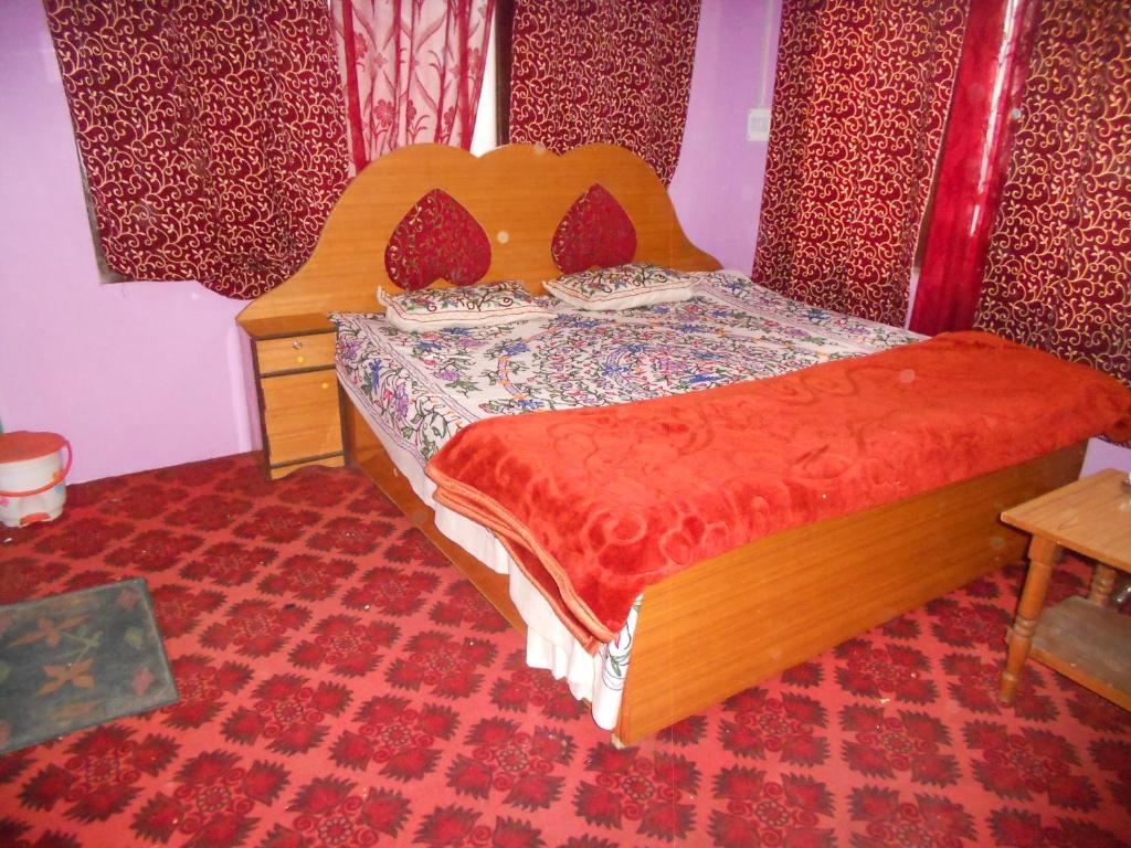 斯利那加Alamdar guest house的一间卧室配有一张带木制床头板的床