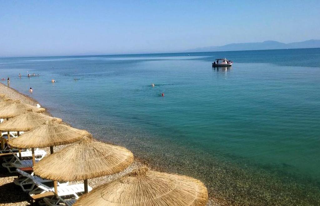 Alissos卡斯泰拉海滩公寓式酒店的海滩上设有遮阳伞和水上船只