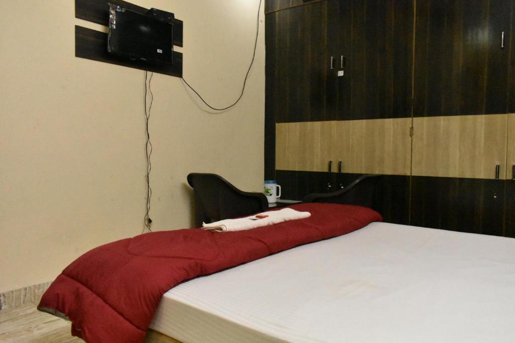 勒克瑙Sudha sadan的一间卧室配有一张带红色毯子的床