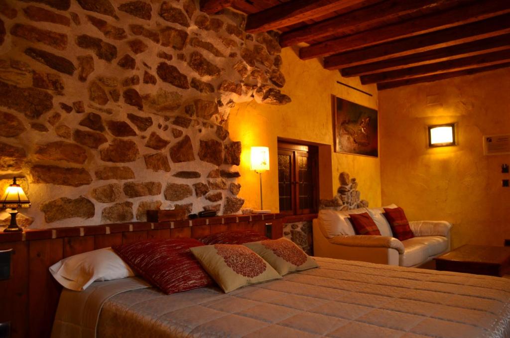 洛索亚河畔布伊特拉戈拉比尔纳夏酒店的一间卧室设有一张床和石墙