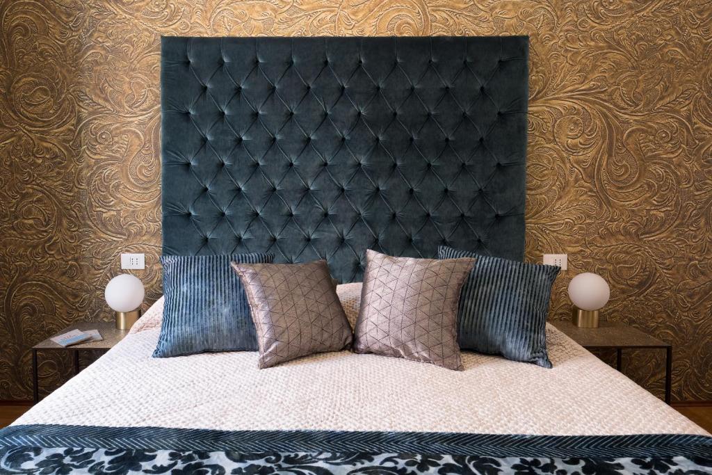 威尼斯B&B Cà del Poeta的一间卧室配有一张大床和黑色床头板