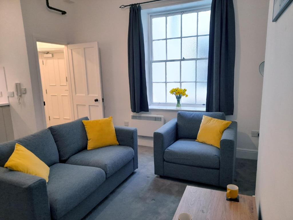 切斯特Eastgate Hideaway - central, luxury apartment on Chester's historic rows的客厅配有2张蓝色的沙发和窗户