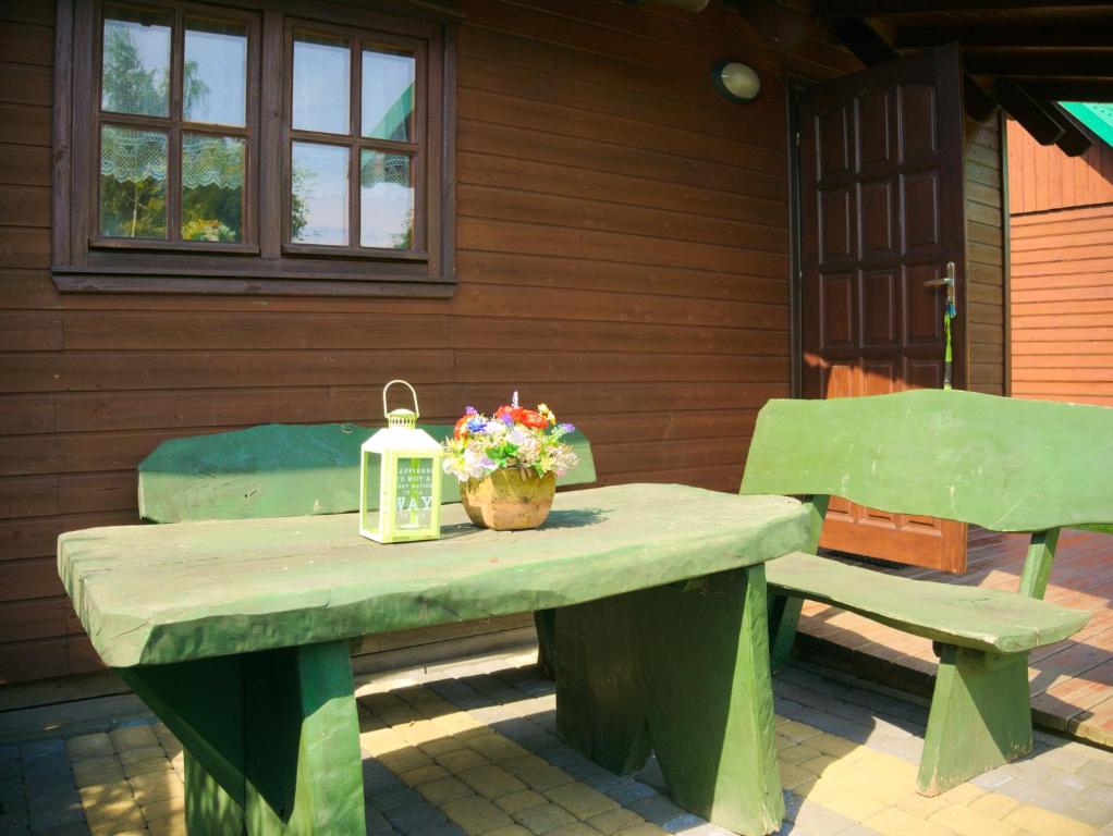 弗瓦迪斯瓦沃沃Agroturystyka Pod Jesionem2的一张带两把椅子的野餐桌、灯笼和鲜花