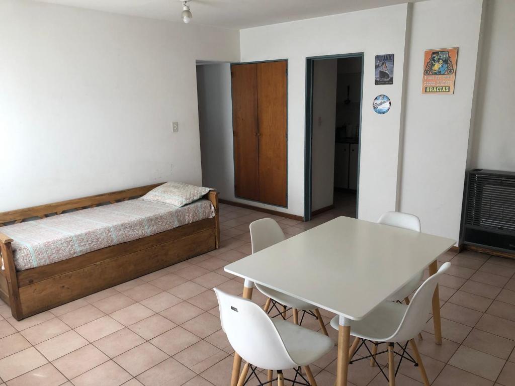 布兰卡港Apartamento Pacifico Suites Centro的配有一张床和一张桌子及椅子的房间