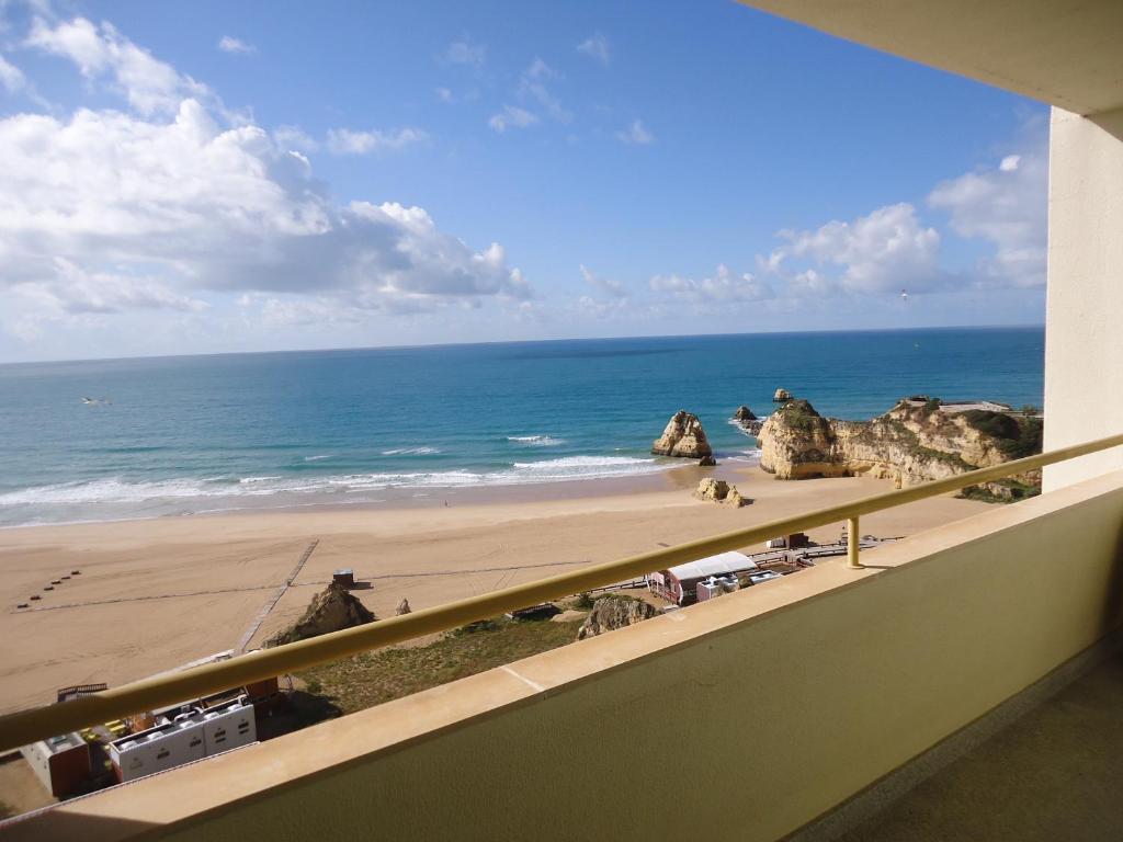 波尔蒂芒Apartamentos Varandas da Rocha的享有海滩和海洋美景的阳台。