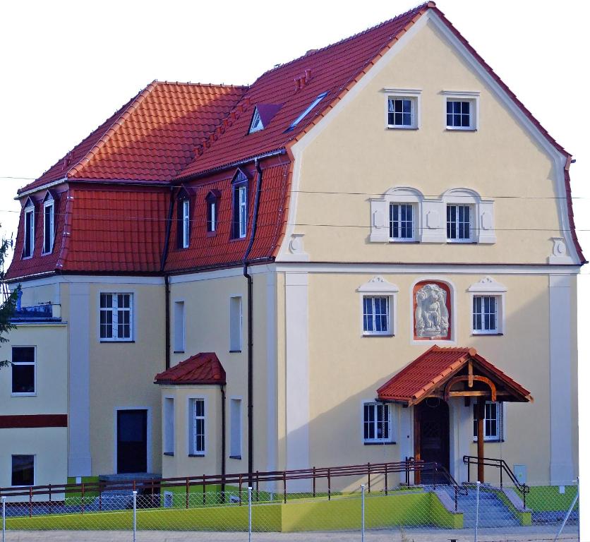 PieniężnoHotelik Hermes的一座大型白色房屋,设有红色屋顶