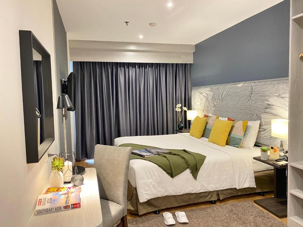 曼谷Evergreen Place Siam by UHG - SHA Extra Plus的一间卧室配有一张床和一张桌子及椅子
