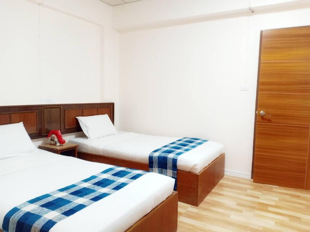 色军帝国沙康酒店的酒店客房设有两张床和一个衣柜。