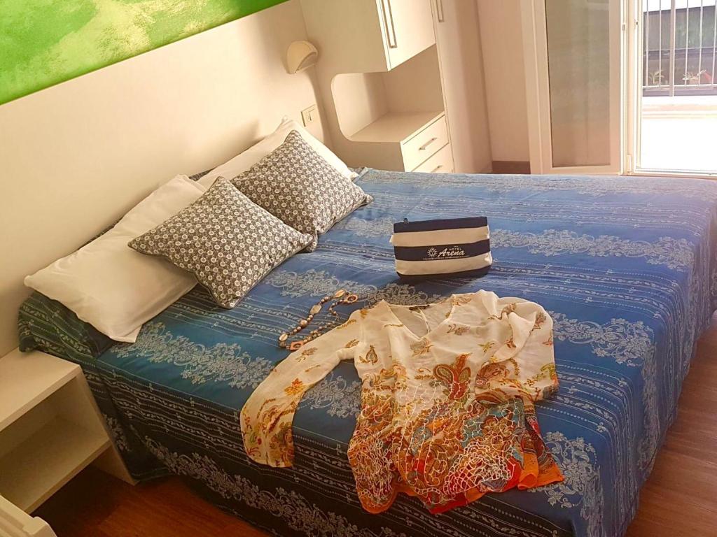 里米尼Hotel Arena的一张带蓝色棉被和枕头的床