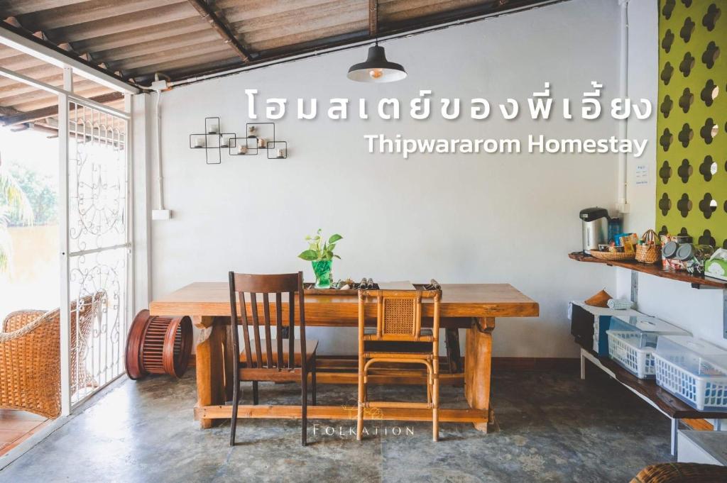 Takua PaThipwararom homestay的一间带木桌和椅子的用餐室