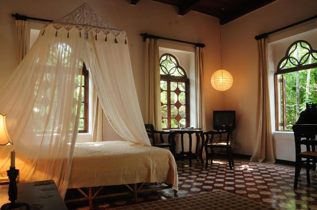SinquerimMarbella Guest House的卧室配有床、桌子和窗户。
