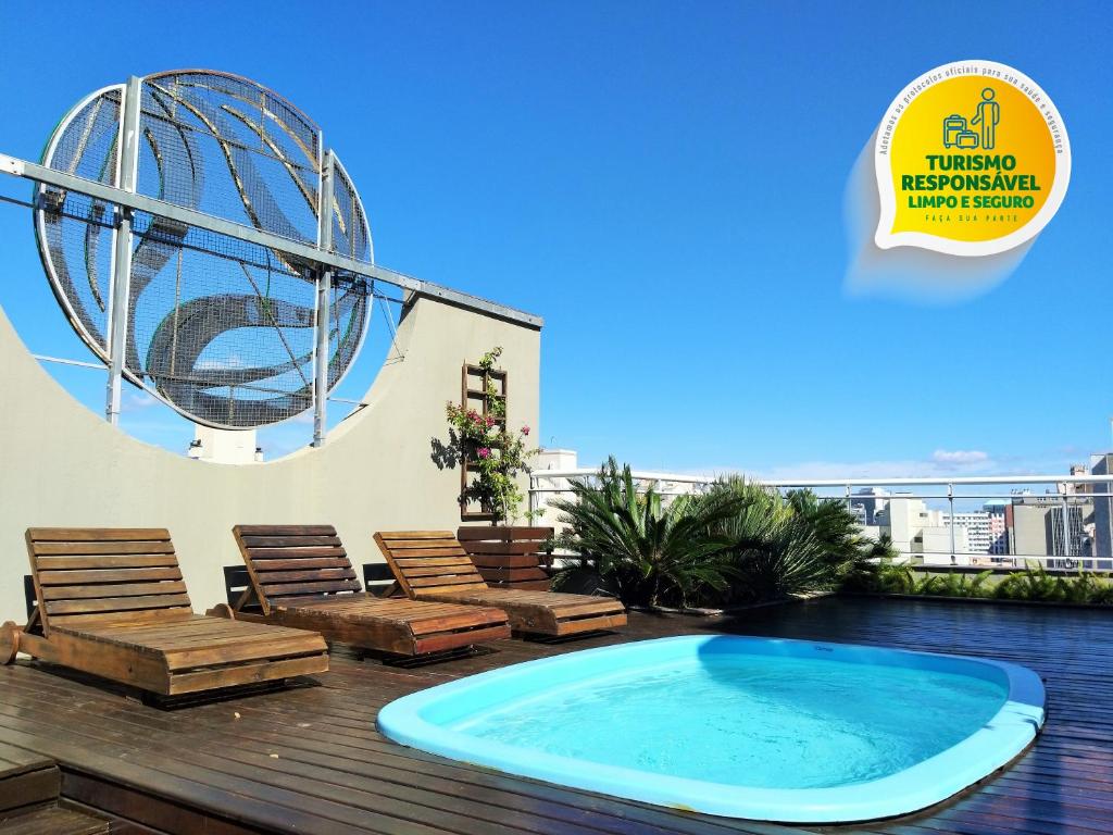阿雷格里港Eko Residence Hotel - a 200m dos Hospitais da Santa Casa的一个带椅子的庭院和一个位于甲板上的大型游泳池