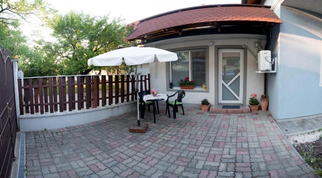 蒂米什瓦拉Cassa Blue的房屋前设有带桌子和遮阳伞的天井。