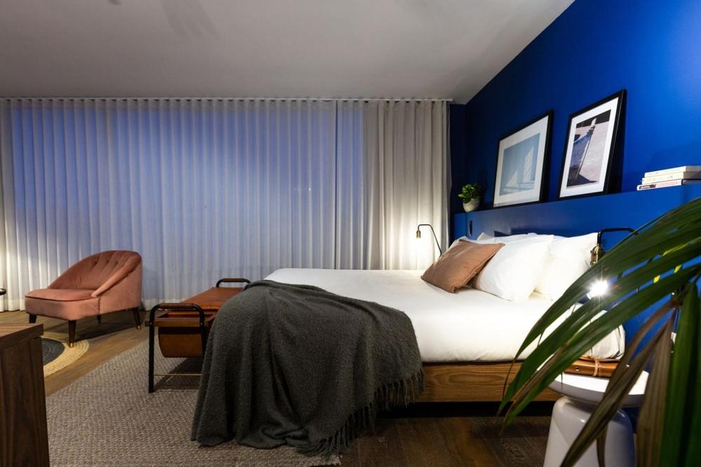 瓦莱塔Guest House de la Valette的一间卧室设有一张床和蓝色的墙壁