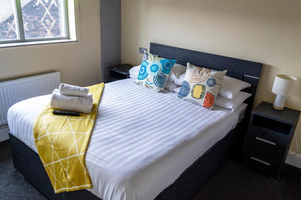 特伦特河畔斯托克Potbank的一间卧室配有一张带色彩缤纷枕头的大床