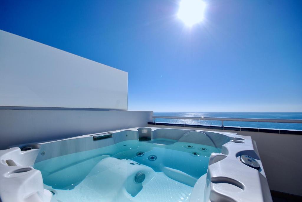 大塔拉哈尔Sea Lovers Jacuzzi Fuerteventura的蓝色灯光客房内的浴缸