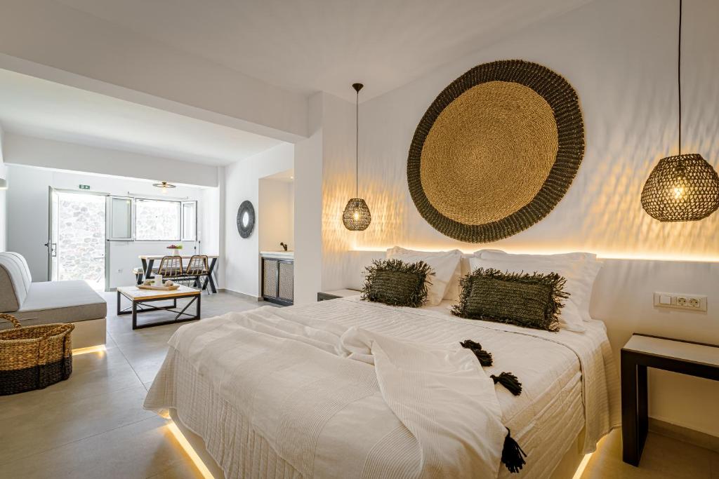 皮尔戈斯Thealos Santorini的一间带白色大床的卧室和一间客厅