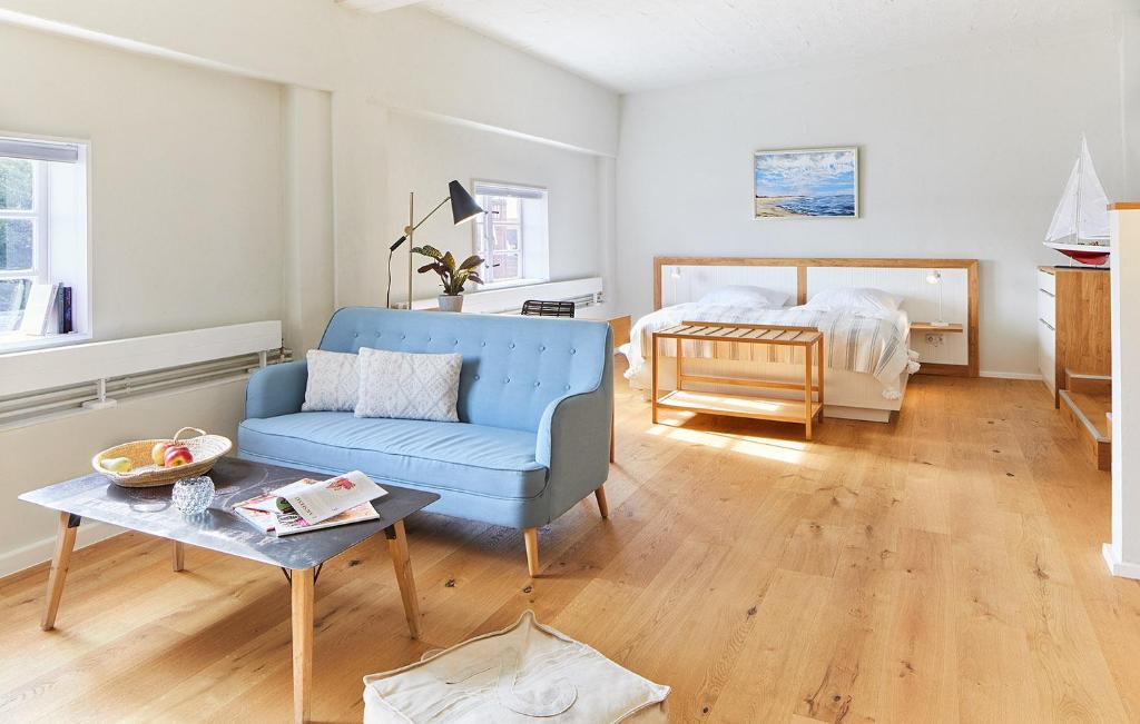 卡珀尔恩Pierspeicher Boardinghouse的客厅配有蓝色椅子和一张床
