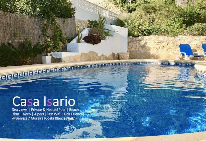 贝尼萨Charming Villa in Montemar with private, heated pool and sea views的庭院内带蓝色椅子的游泳池