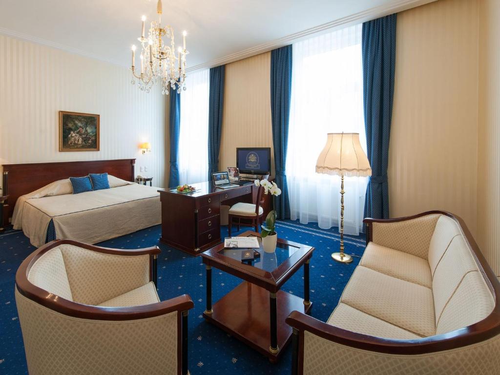 维也纳国宾酒店的酒店客房带一张床、一张桌子和椅子