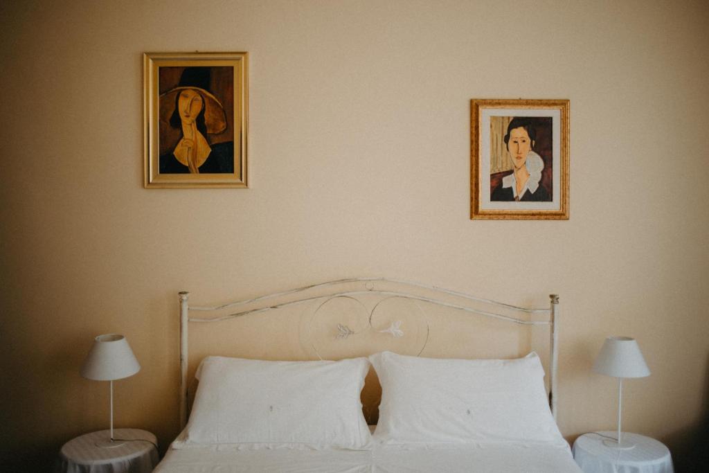 莱切阿根广场旅馆的卧室配有一张墙上有两张照片的床。