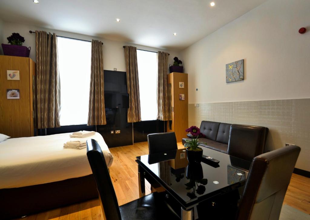 伦敦海德公园公寓的酒店客房,配有一张床、一张桌子和椅子
