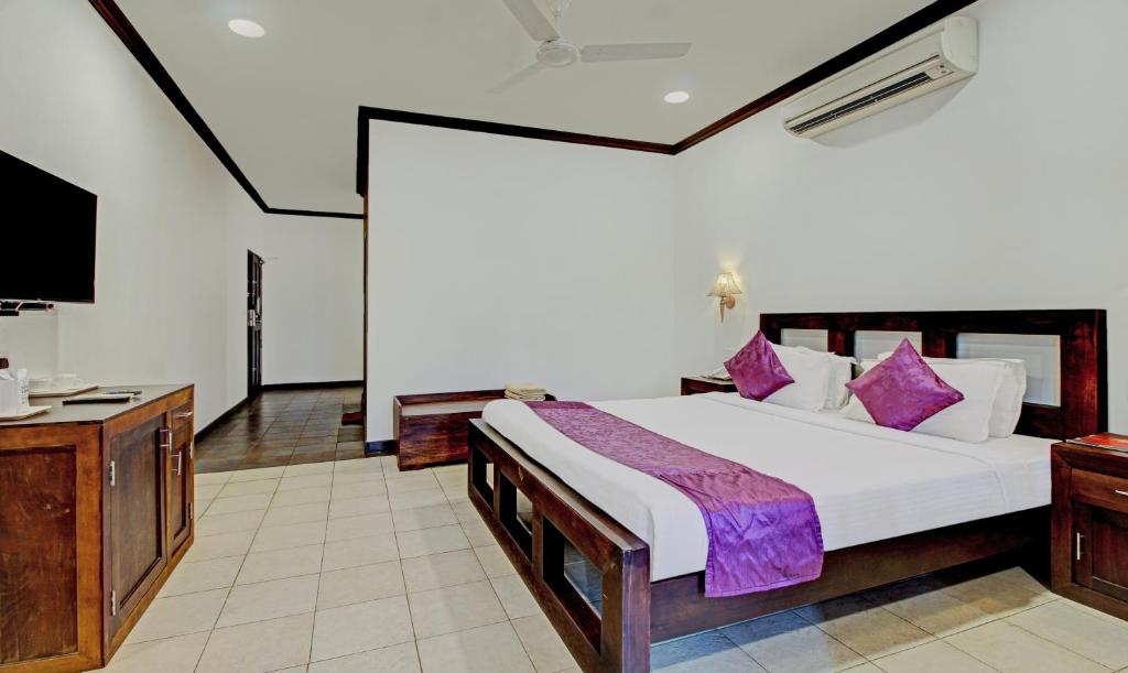 AlleppeyTreebo Tryst Travancore Palace Cherthala的一间卧室配有一张大床和电视