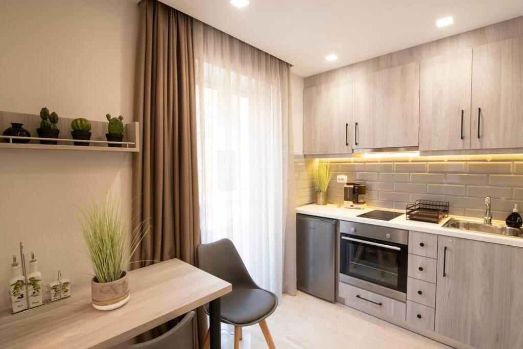 科斯镇Αqua Dream Beach Apartment的厨房配有水槽和炉灶 顶部烤箱