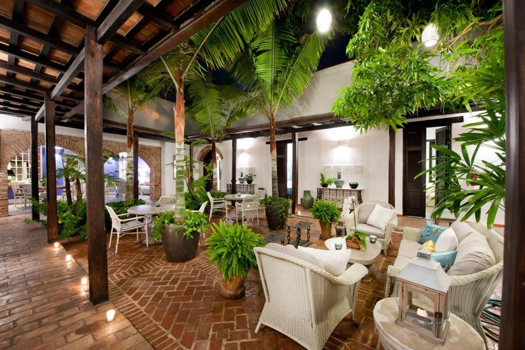 圣多明各Casas del XVI的客厅配有白色家具和棕榈树