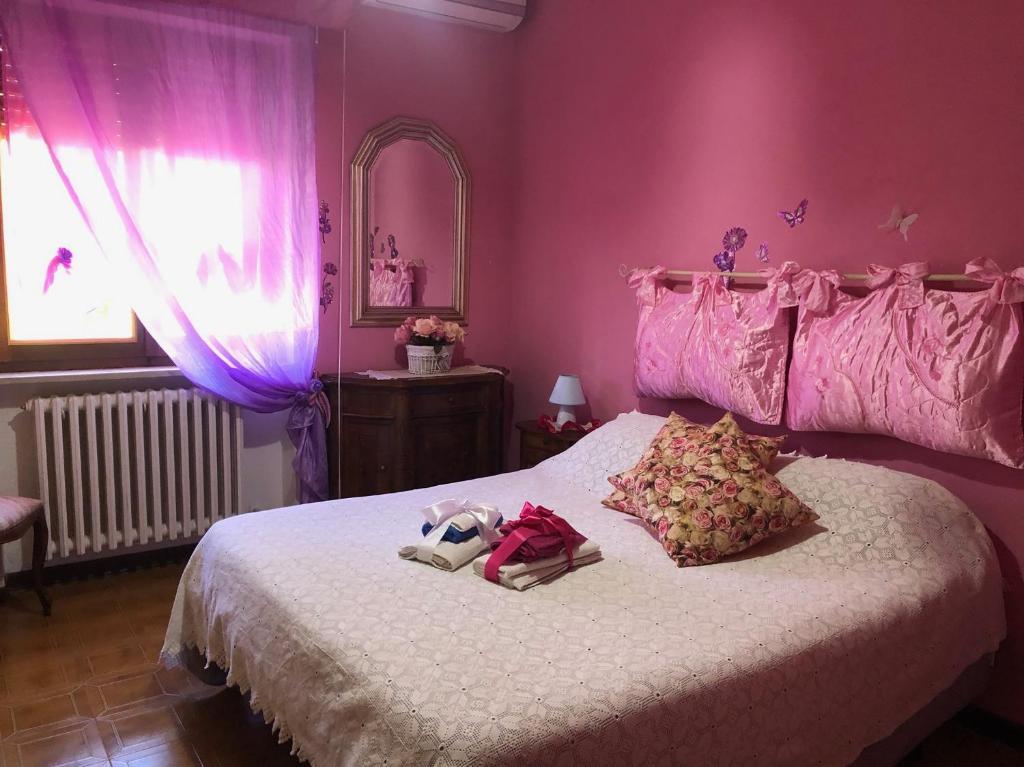 博尔塞纳B&b ANNA的粉红色的卧室,床上有一只动物