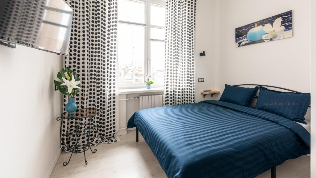 明斯克Aparthotel ЦЕНТР у Центрального Вокзала Минск-Пассажирский的一间卧室设有蓝色的床和窗户。