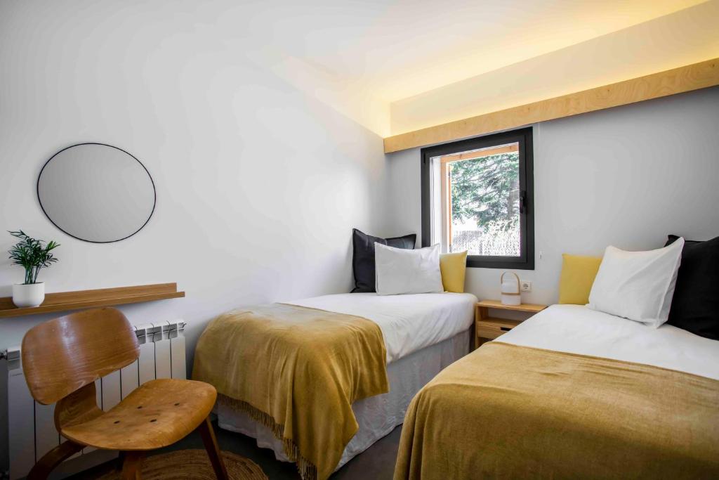 纳瓦塞拉达Finca el Veinti9的一间设有两张床、椅子和镜子的房间