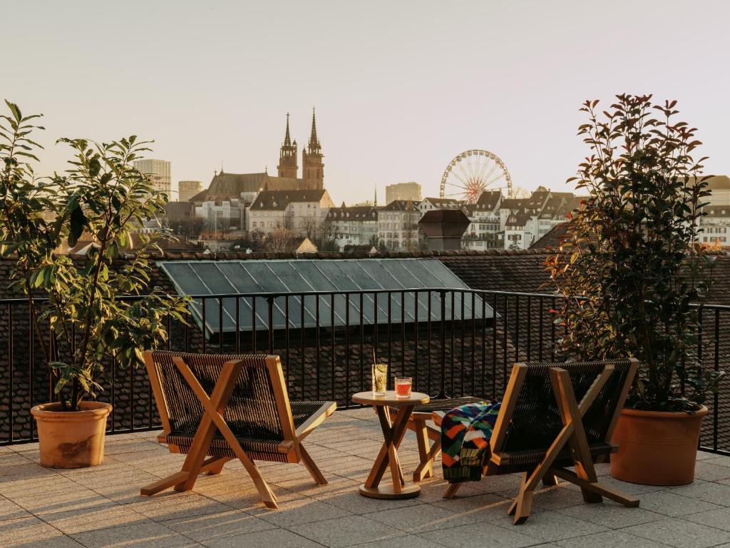 巴塞尔Boutique & Design Hotel Volkshaus Basel的屋顶上两把椅子和一张桌子