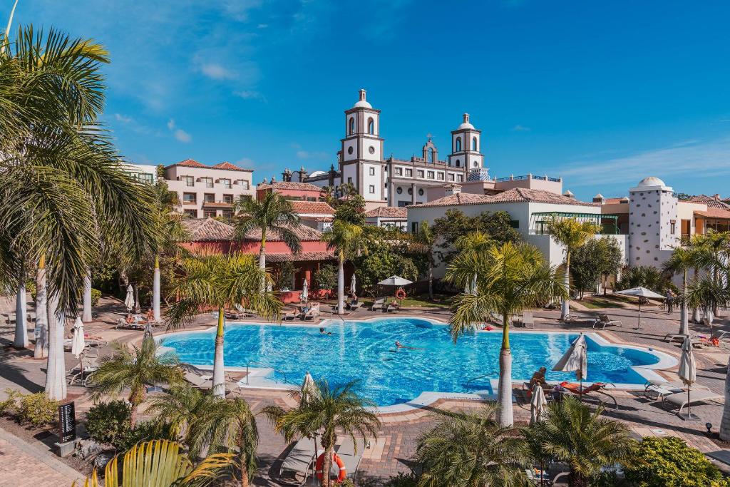 梅罗那瑞斯Lopesan Villa del Conde Resort & Thalasso的享有带游泳池和棕榈树的度假村景色