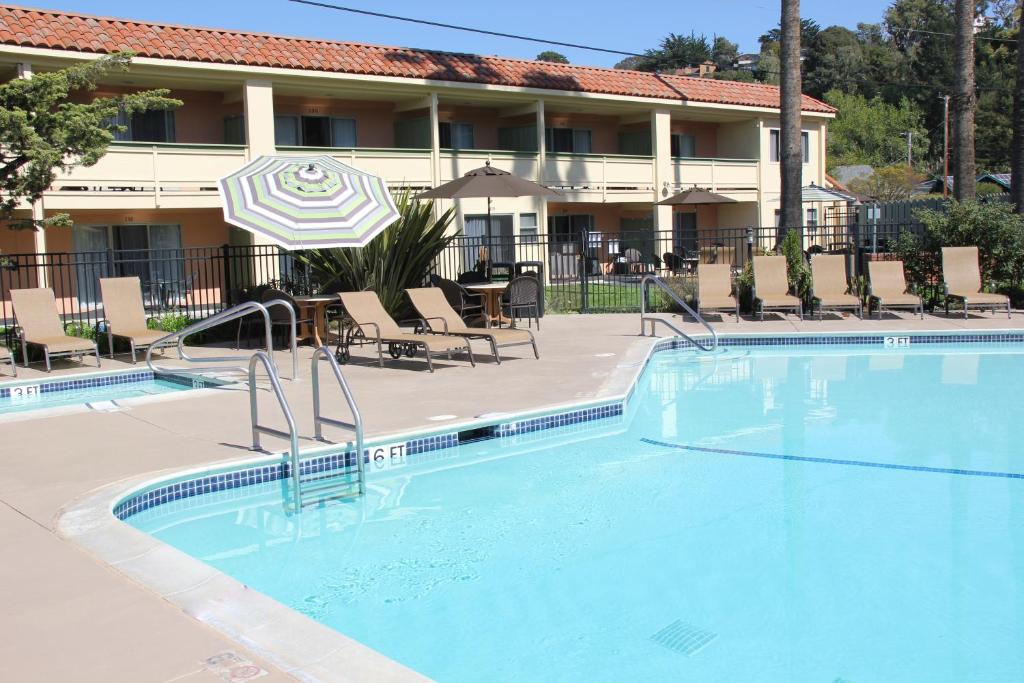 阿普托斯Rio Sands Vacation Rentals的酒店前的游泳池配有椅子和遮阳伞