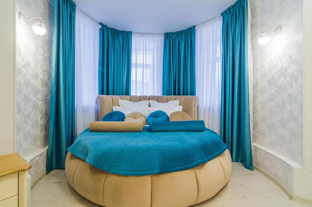 彼尔姆Versal Hotel Perm的一间卧室配有一张大床和一个大搁脚凳