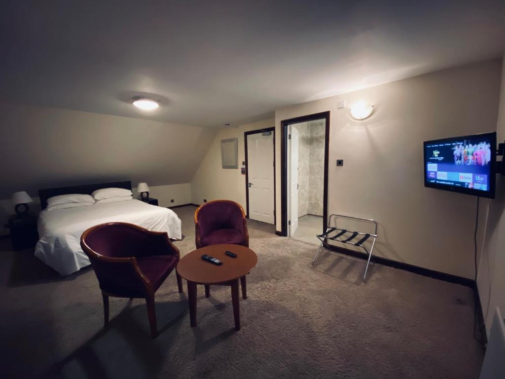 波茨莱德Clifton House Brighton的酒店客房带一张床、一台电视和椅子