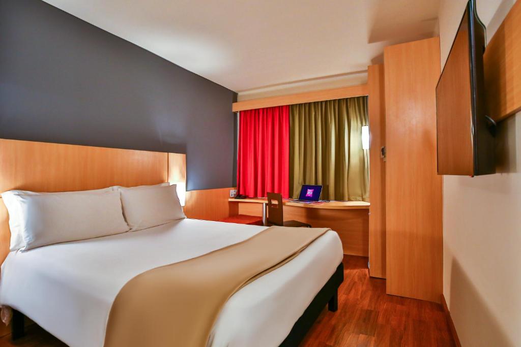 里约热内卢里约博塔弗戈宜必思酒店的一间卧室设有一张大床和红色窗户。