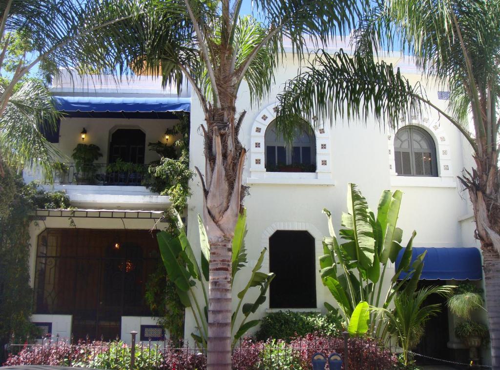 瓜达拉哈拉珍珠酒店精品住宿加早餐旅馆的一座白色的建筑,前面有棕榈树