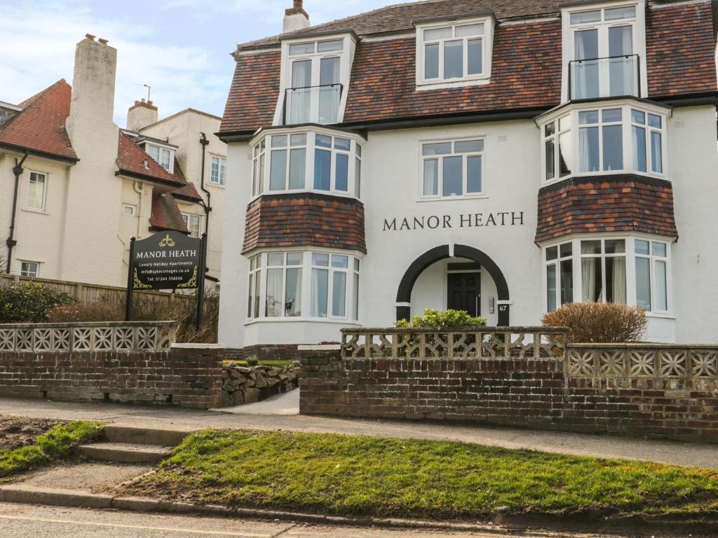 斯卡伯勒Manor Heath Apartment 2的一座白色的建筑,拥有庄园的心脏旅馆