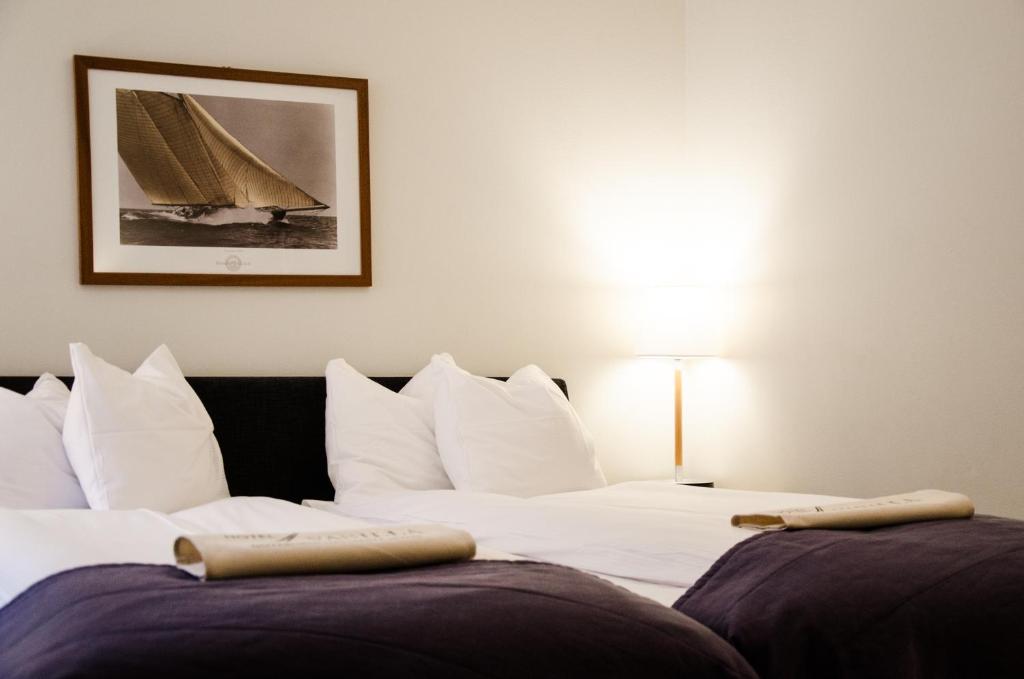 哥德堡香草酒店的一间卧室配有两张床,一张帆船的照片