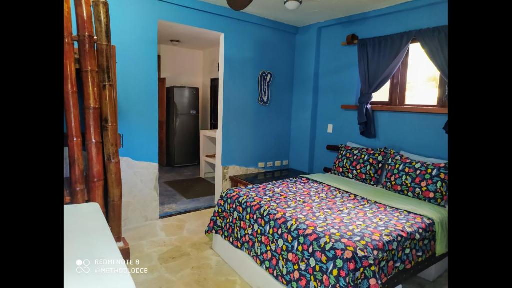 喀巴里特Room in Lodge - Method Living Tropical Edition的一间卧室设有一张床和蓝色的墙壁