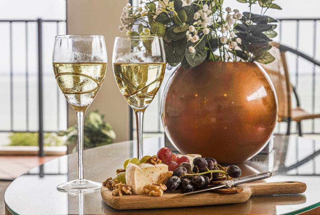 达尔文ZEN AT THE ESPLANADE - Spectacular Sunset Retreat的一张桌子,上面放着两杯葡萄酒和一盘食物