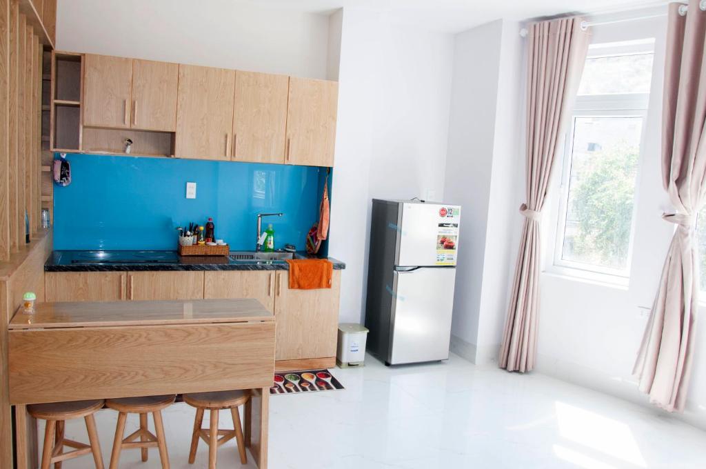 头顿COCA HOTEL & APARTMENT的厨房配有冰箱和带凳子的台面