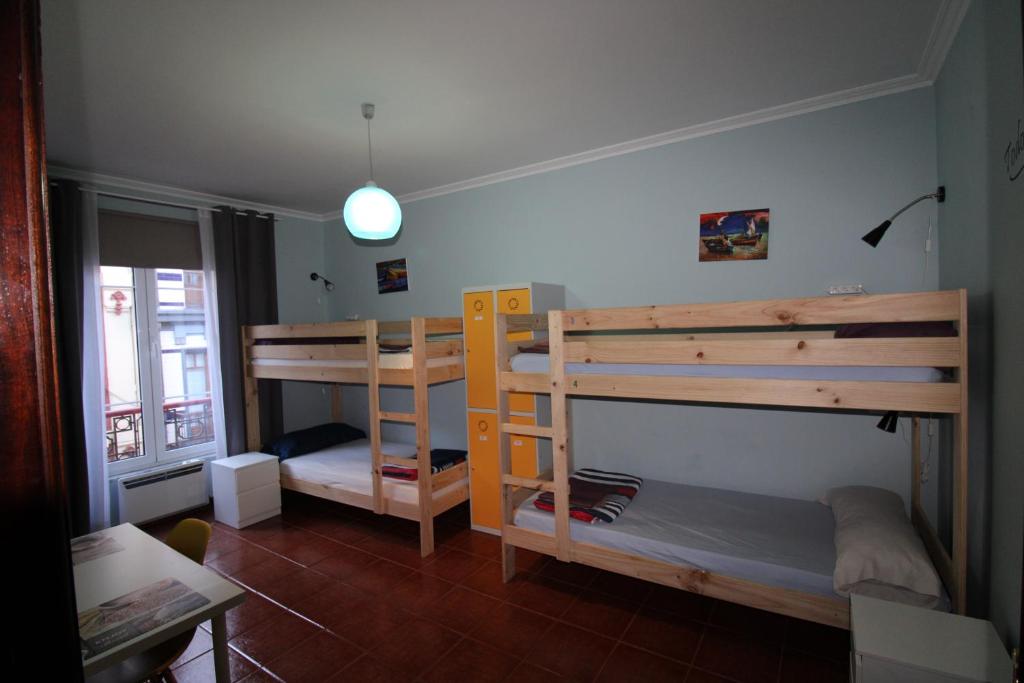 希洪Hostel GoodHouse Gijón的客房设有两张双层床和一张桌子。