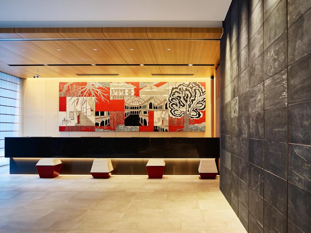 东京Mitsui Garden Hotel Ginza-gochome的大堂设有长椅和墙上的绘画