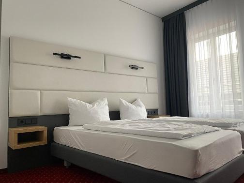 纽伦堡大陆饭店的一间卧室配有一张大床、床头板和窗户
