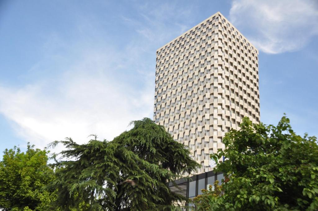 地拉那Maritim Hotel Plaza Tirana的前面有树木的高楼