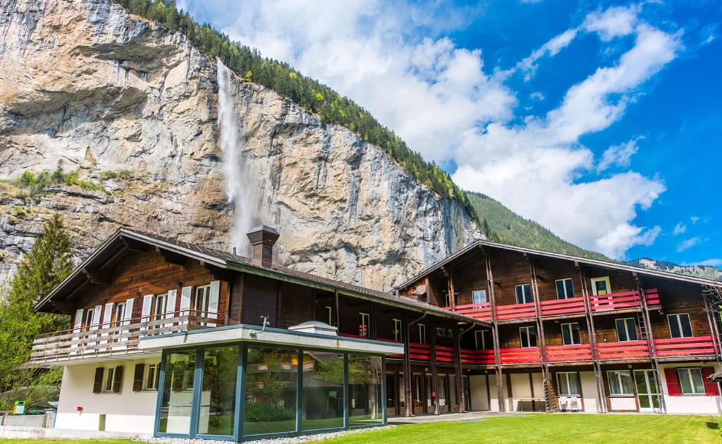 劳特布龙嫩Alpine Base Hostel - Adults only的山前的一座建筑,有瀑布